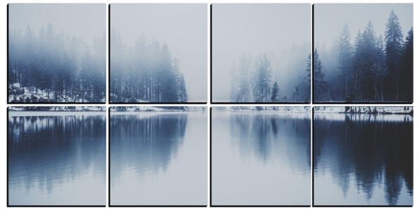 Foggy lake surrounded by snow covered forest